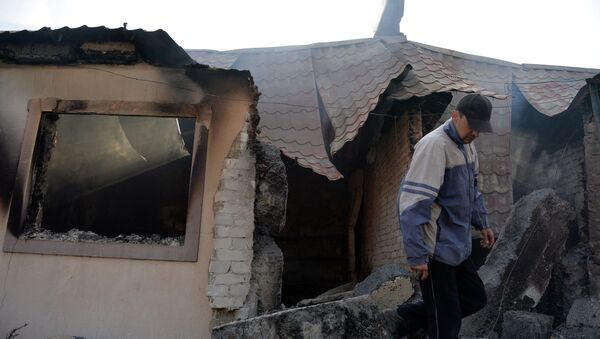 Мужчина у своего дома, разрушенного в результате артиллерийского обстрела украинскими силовиками города Донецка