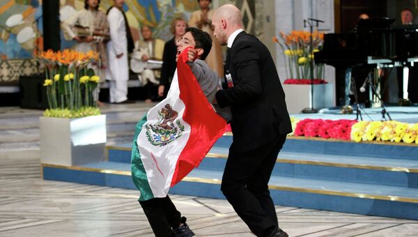 Неизвестный мужчина с мексиканским флагом на сцене во время награждения Нобелевской премией мира в Осло
