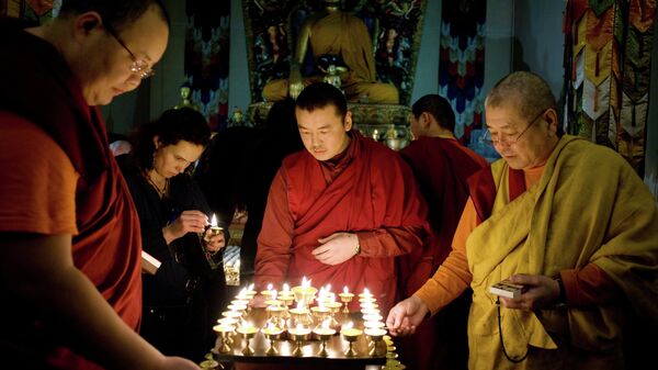 Монахи в петербургском буддийском храме зажигают свечи в день Праздника тысячи лампад (Зула-хурал)