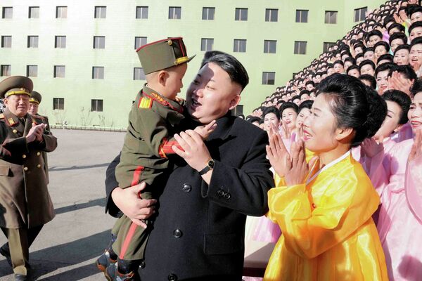 Северокорейский лидер Ким Чен Ын держит мальчика после фотосессии