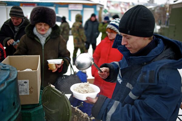Работник аварийно-спасательной службы раздает еду на востоке Украины, 5 декабря 2014 год