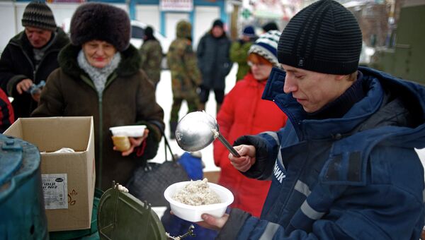 Работник аварийно-спасательной службы раздает еду на востоке Украины. Архивное фото