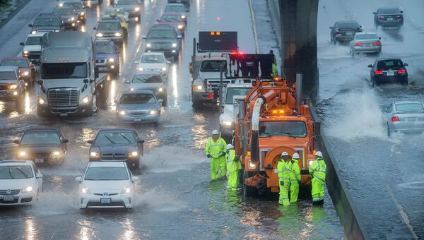 Работники коммунальной службы пытаются справиться с затопленным во время зимнего шторма участком шоссе в Сан-Франциско, 2014 год