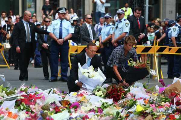 Премьер-министр Австралии Тони Эббот и его жена Марджи возлагают цветы на месте захвата заложников в Сиднее