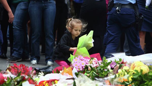Люди несут цветы в память о погибших в кафе в Сиднее, Австралия