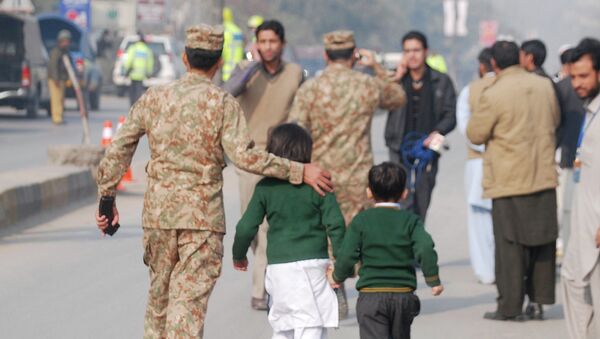 Пакистанские силы безопасности неподалеку от военного училища в Пакистане, захваченного боевиками. 16 декабря 2014