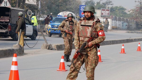 Пакистанские силы безопасности неподалеку от военного училища в Пакистане, захваченного боевиками. 16 декабря 2014
