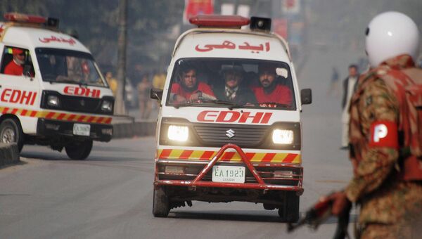 Автомобили скорой помощи неподалеку от военного училища в Пакистане, захваченного боевиками