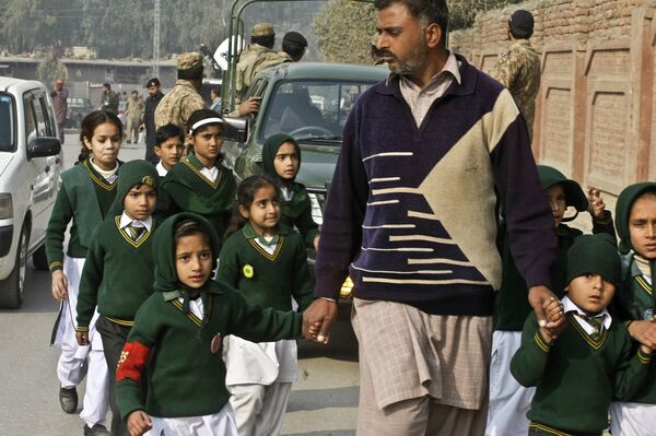 Школьники неподалеку от военного училища в Пакистане, захваченного боевиками