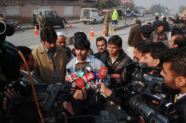 Мужчина дает интервью неподалеку от военного училища в Пакистане, захваченного боевиками
