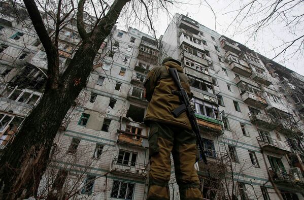 Боец ополчения возле поврежденного обстрелами дома в районе Донецкого аэропорта