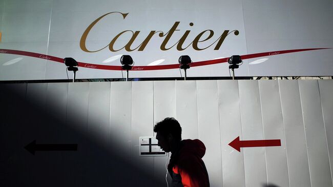 Прохожий на фоне рекламного баннера Cartier. Архивное фото