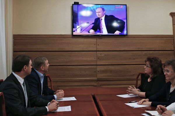 Мэр Калининграда Александр Ярошук (второй слева) смотрит телетрансляцию большой пресс-конференции президента России Владимира Путина