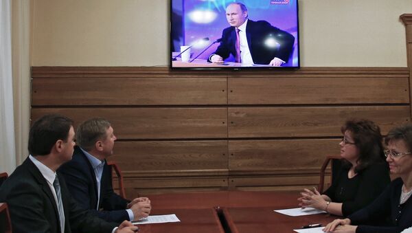 Мэр Калининграда Александр Ярошук (второй слева) смотрит телетрансляцию большой пресс-конференции президента России Владимира Путина