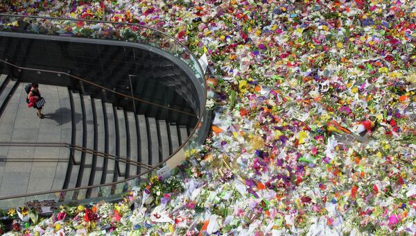Множество цветов  в память, о погибших заложников в Сиднее