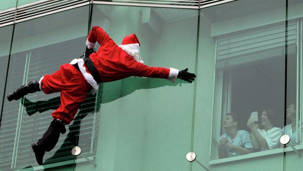 Боец спецназа переодетый в Санта-Клауса спускается с крыши госпиталя города Любляна, Словения