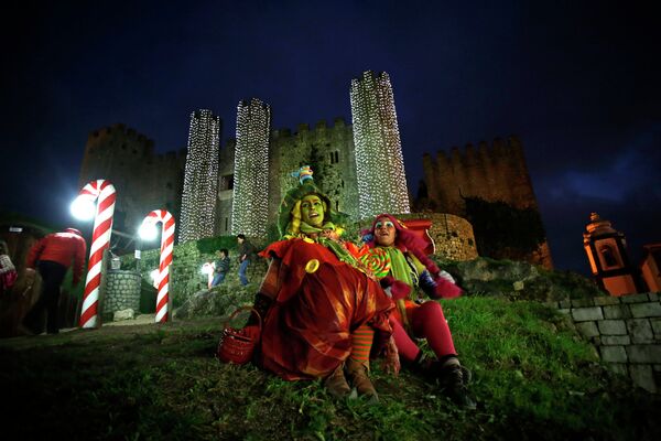 Женщины, переодетые эльфами, во время рождественского представления возле замка Обидуш, Португалия