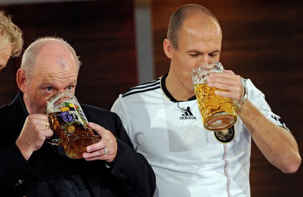 Британский музыкант Джо Кокер и футболист Баварии Арьен Роббен пьют пиво в эфире развлекательного шоу Wetten, dass..?