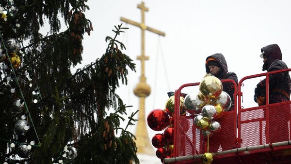Рабочие украшают главную новогоднюю елку России на Соборной площади Московского Кремля. Архивное фото