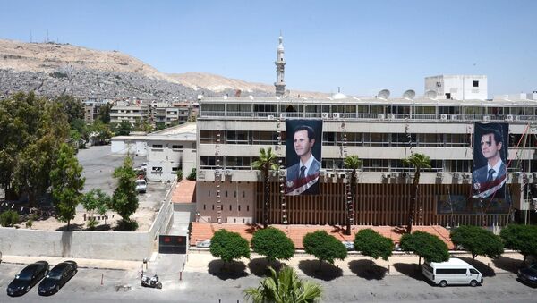 Плакаты с портретом президента Сирии Башаром Асадом на здании в Дамаске. Архивное фото