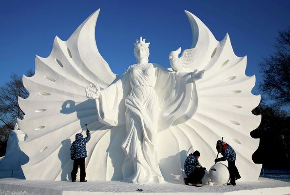 Участники из Польши сооружают скульптуру из снега на фестивале в Харбине
