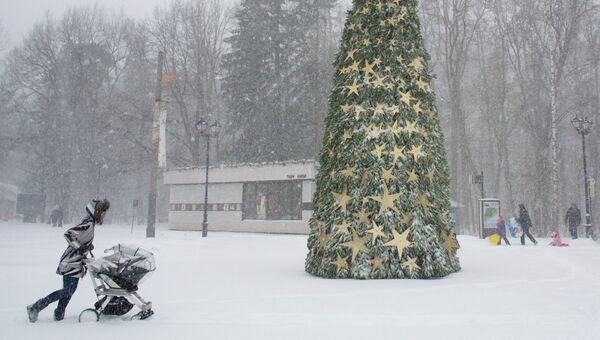Женщина с коляской во время снегопада в Москве