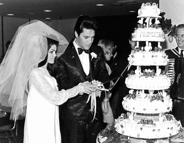 Американский певец Элвис Пресли и Присцилла Пресли режут свадебный торт