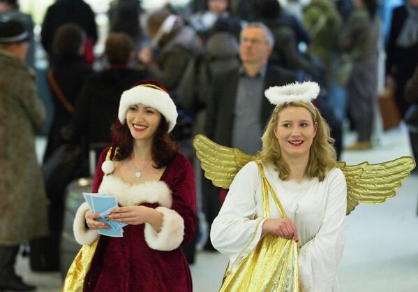 Девушки в костюмах Санта-Клауса и ангела в аэропорту Берлина