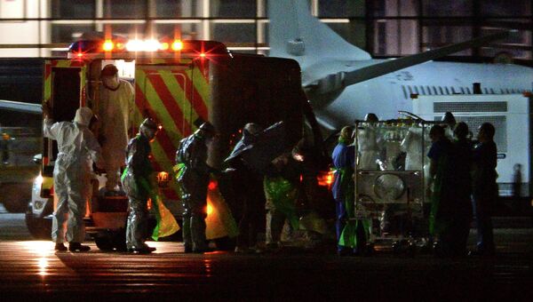 Шотландских медработников перевозит женщину с диагнозом Эбола в аэропорту Глазго. 30 декабря 2014