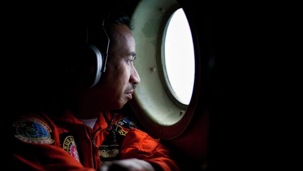 Член экипажа самолета ВВС Индонезии во время поисков пропавшего самолета компании Air Asia
