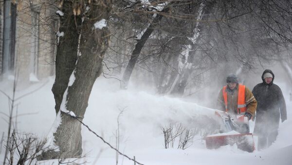 Сотрудник служб ЖКХ очищает двор от снега, Украина. Архивное фото