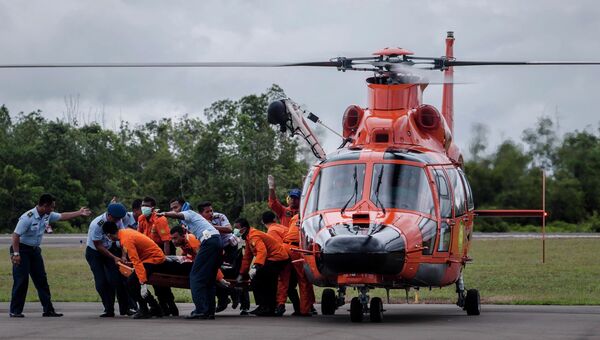 Индонезийские спасатели несут тело пассажира самолета авиакомпании AirAsia. 31 декабря 2014