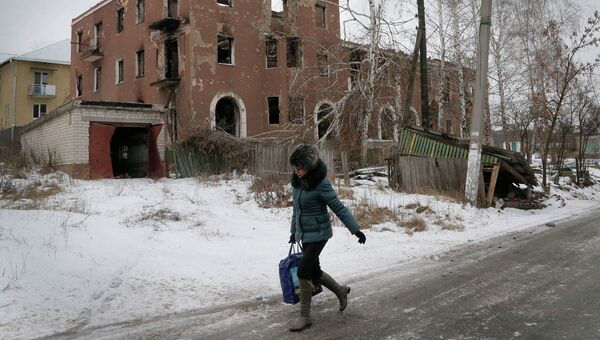 Женщина проходит мимо разрушенного дома в Семеновке, Донецкая область, Украина. Архивное фото