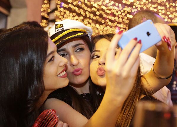 Люди фотографируются на смартфон во время празднования Нового года в Бейруте