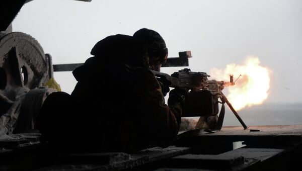 Боец украинского добровольческого батальона стреляет из автомата. 3 января 2015