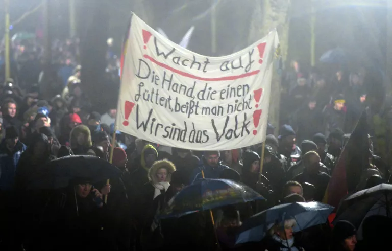 Участники акции протеста в Германии, выступающие против нетерпимости в отношении иммигрантов и движения Pegida Участники акции протеста в Германии, выступающие против нетерпимости в отношении иммигрантов и движения Pegida