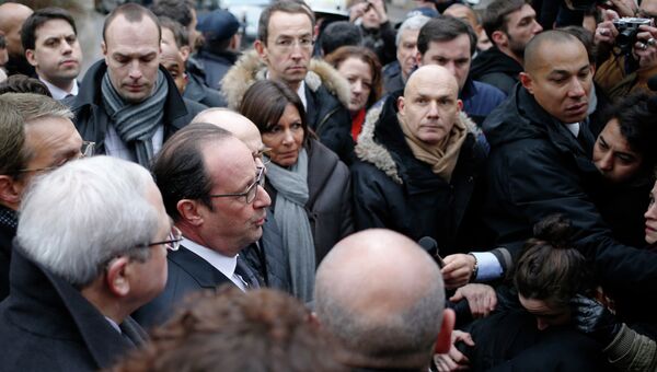 Президент Франции Франсуа Олланд общается с прессой возле офиса издания Charlie Hebdo в Париже