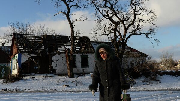 Женщина проходит мимо здания, разрушенного в результате боевых действий в деревне Степановка, Украина. Архивное фото