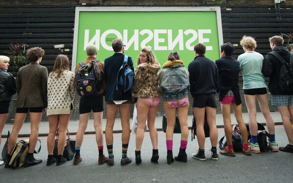 Люди позируют фотографу перед участием в ежегодной акции в метро без штанов