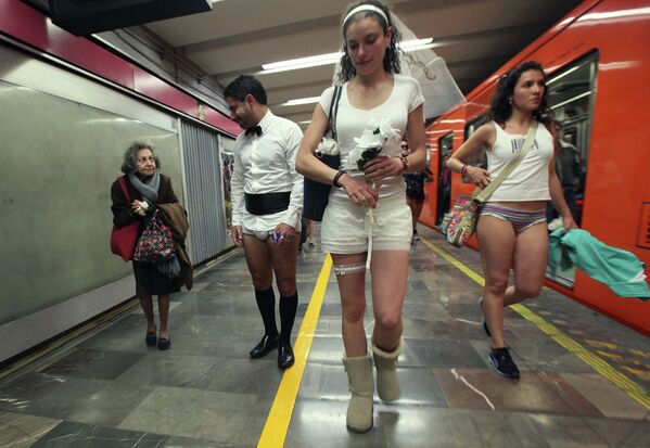 Пожилая женщина смотрит на молодых людей принимающих участие в ежегодной акции в метро без штанов