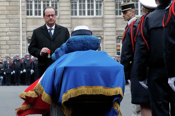 Президент Франции Франсуа Олланд перед гробом офицера полиции, погибшего в результате теракта в Париже