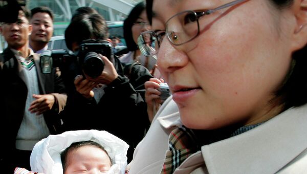 Жительница Южной Кореи Хван Сон с ребенком. Архивное фото