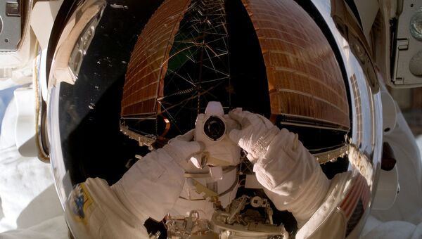 Отражение фотокамеры астронавта в открытом космосе. Архивное фото