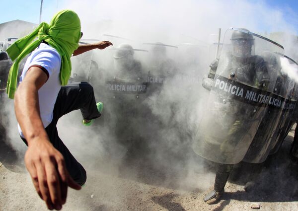Активист и полиция во время беспорядков в Игуале, Мексика