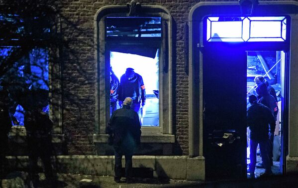 Сотрудники бельгийской полиции инспектируют жилое здание во время антитеррористической операции в городе Вервье. 15 января 2015