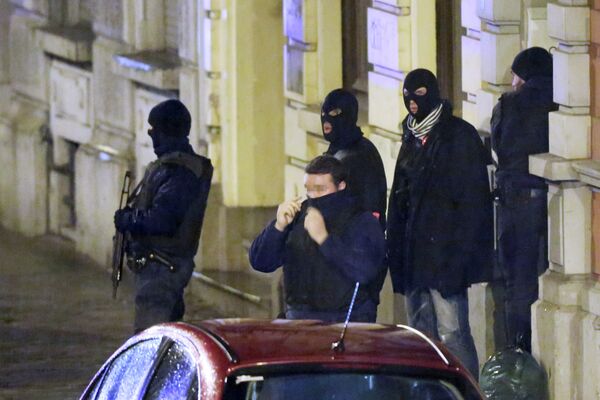 Сотрудники бельгийской полиции у входа жилое здание во время антитеррористической операции в городе Вервье. 15 января 2015