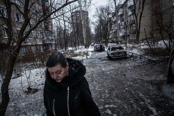 Женщина на улице в Донецке после обстрела украинскими силовиками