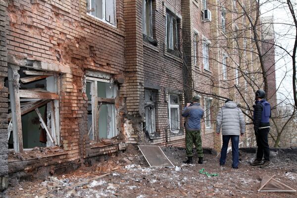 Журналисты осматривают больницу, поврежденную в результате обстрела Донецка украинской армией