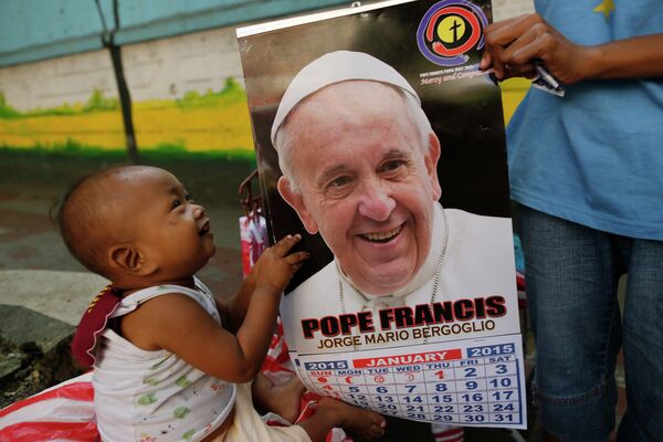 Ребенок держит календарь с изображением Папы Римского Франциска