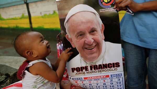 Ребенок держит календарь с изображением Папы Римского Франциска